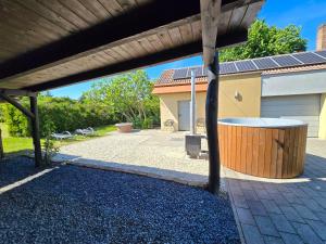 a covered patio with a trash can and a building at Nr 25 Ferienhaus Astor in Keszthely