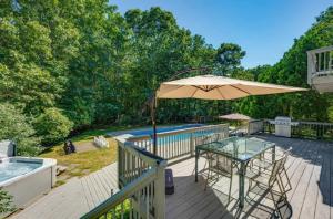 a deck with a table and an umbrella at Entertainment Galore, Meadowood Manor by RoveTravel in Sag Harbor