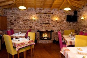 a restaurant with two tables and a fireplace at Archontiko in Andritsaina