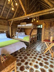 a bedroom with two bunk beds and a table at Jardin de los Silleteros Agro Parque Hotel in Santa Elena