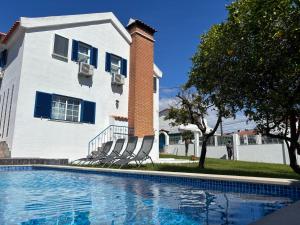 a house with a swimming pool in front of a house at Casa do Rei Aroeira in Charneca