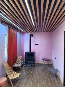 un salon avec un poêle à bois et des chaises dans l'établissement Villa Cottage Merisi, à Inasharidzeebi