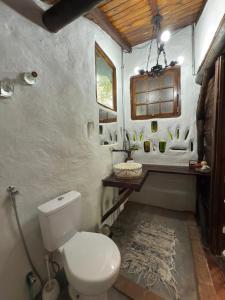 une salle de bain avec des toilettes blanches et un lavabo dans l'établissement Ecocentro Brasil - Bangalô Flamboyant, à São Pedro 35 autres photos