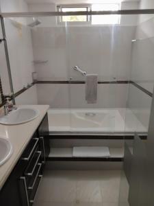 a bathroom with a glass shower and a sink at Hotel PREMIUM HOUSE in Floridablanca +29 photos