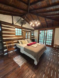 - une chambre avec un lit dans un dortoir doté de parquet dans l'établissement Ecocentro Brasil - Bangalô Flamboyant, à São Pedro