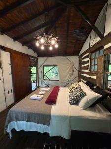 - une chambre avec un grand lit dans une maison dans l'établissement Ecocentro Brasil - Bangalô Flamboyant, à São Pedro