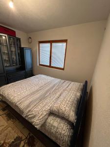 een slaapkamer met een bed en een raam bij Buća Potok Aurrora in Sarajevo