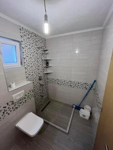 een badkamer met een douche, toilet en wastafel bij Buća Potok Aurrora in Sarajevo
