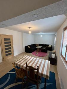 een woonkamer met een tafel en een bank bij Buća Potok Aurrora in Sarajevo