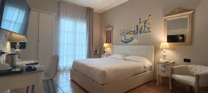 a bedroom with a bed and a desk and a chair at Hotel Palladium in Monastir