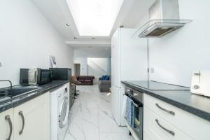 a kitchen with white cabinets and a counter top at Ephatha House 4-Bedrooms, Sleeps 11, Free Parking, Garden in Hatfield