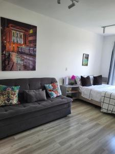 a living room with a couch and a bed at Studio with a beautiful view in Curitiba