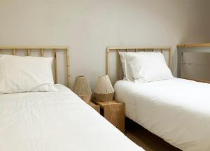 Dos camas una al lado de la otra en un dormitorio. en Sol Cinco, en Arelho