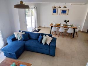 a blue couch in a living room with a table at Villa DAMAKI in Kriopigi