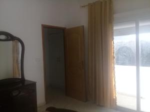 a room with a door and a window with curtains at Rare opportunité Maison à louer au cœur de la Corniche de Bizerte, à proximité des grottes in Banzart +2 photos