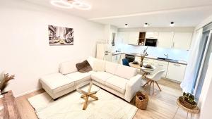a living room with a white couch and a kitchen at Scandi Apartment with Terrace and Parking in Karlsruhe +17 photos