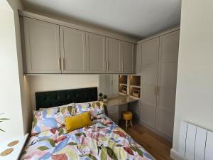 a bedroom with a bed and a desk and cabinets at Luxury studio apartment, Skipton in Skipton