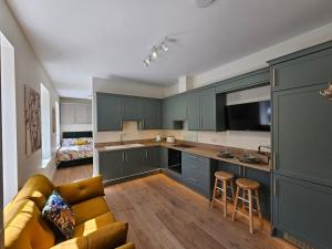 a kitchen with blue cabinets and a couch in a room at Luxury studio apartment, Skipton in Skipton