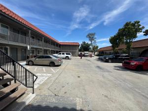 a parking lot with cars parked in front of a building at Vista Motel - Riverside in Riverside +1 photo