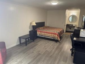 a bedroom with a bed and a table and a mirror at Vista Motel - Riverside in Riverside