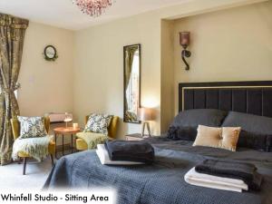 a bedroom with two beds and a sitting area at Honeysuckle Cottage & Whinfell Studio in Penrith