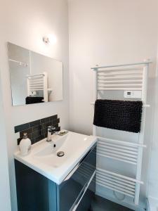 un bagno con un lavandino bianco e uno specchio di Le Faubourg a Pamiers