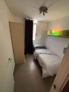 two beds in a small room with a door at Appartement VILLAJOYOSA 98m2 PROCHE DE LA MER in Villajoyosa