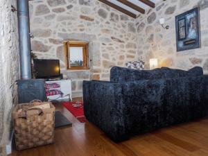 a living room with a couch and a stone wall at Casa da Gandarela in Soajo