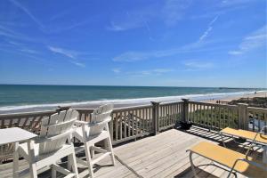 a deck with chairs and tables and the beach at C-Breeze in Surf City