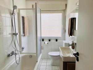 ビュッケブルクにあるCozyHomeのシャワー、トイレ、洗面台を備えたバスルーム +9枚の写真