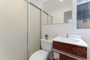 a bathroom with a toilet and a sink and a mirror at The Cozy Apartment in San Salvador +31 photos
