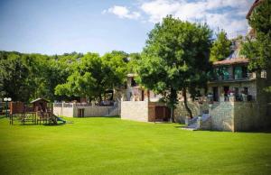 a large yard with a building and a grass field at Shasi Eco Lodge in Ambula