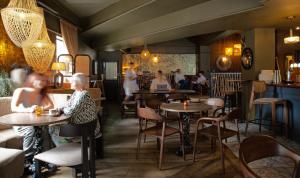 a group of people sitting at tables in a restaurant at Piccadilly Central in Manchester +67 photos