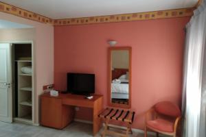 a room with a television and a desk with a mirror at Mercedes Park Hotel in Villa Mercedes