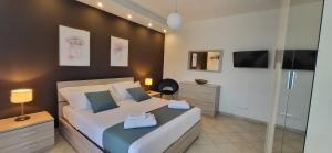 een slaapkamer met een groot bed en een televisie bij NüMa Apartment in Assemini