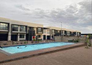 a large swimming pool in front of a building at Blue Diamond Luxe-Setlhoa in Gaborone