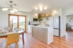 a kitchen with white cabinets and a table with chairs at Lake Lawtonka View Mountaintop Medicine Park Home in Medicine Park