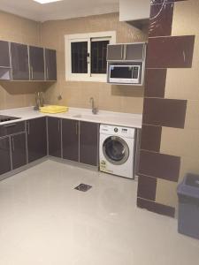 cocina con lavadora y microondas en Rukon Buotat 15, en Riad