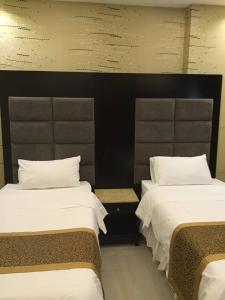 Habitación con 2 camas y almohadas blancas. en Rukon Buotat 15, en Riad
