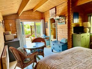 a bedroom with a bed and a table in a room at The Log Cabin in Wimborne Minster