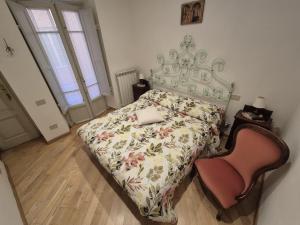 a bedroom with a bed and a chair at The Clock Tower Apartment in Lucca