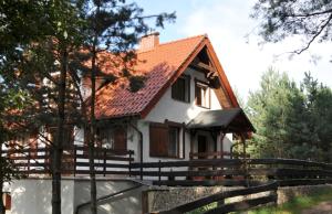 a small white house with a red roof at Wczasy na Kaszubach, balia, sauna, jezioro in Wąglikowice