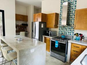 a kitchen with a stove and a refrigerator at Bright, Stylish Home Near the Beach with Shared Pool in El Pescadero