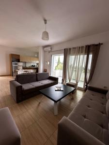 a living room with a couch and a table at Suzi's apartment in Dhërmi
