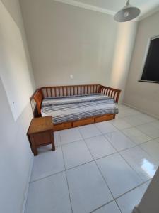 a bedroom with a bed and a table on a tiled floor at Casa shalom in Serra Negra +6 photos