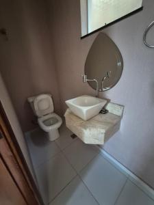 une salle de bains avec lavabo, toilettes et miroir dans l'établissement Casa shalom, à Serra Negra