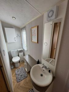 a bathroom with a sink and a toilet at Golden Palm Resort - Willerby Avonmore - Coastal Caravan Breaks in Chapel Saint Leonards +17 photos