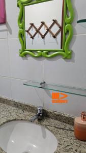ein Waschbecken im Bad mit einem grünen Spiegel darüber in der Unterkunft Casa de Meg Charme e Natureza na Serra Negra in Bezerros