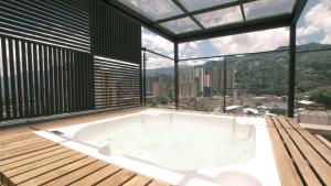 a bath tub in a room with a large window at Apartamento Premium Sabaneta in Sabaneta