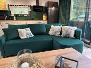 a green couch in a living room with a table at Forest Mood in Wieck